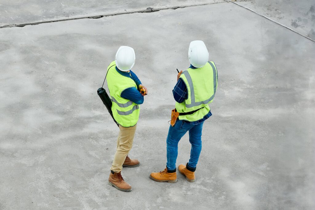 Construction workers at a construction site looking into the distance viewed from behind them